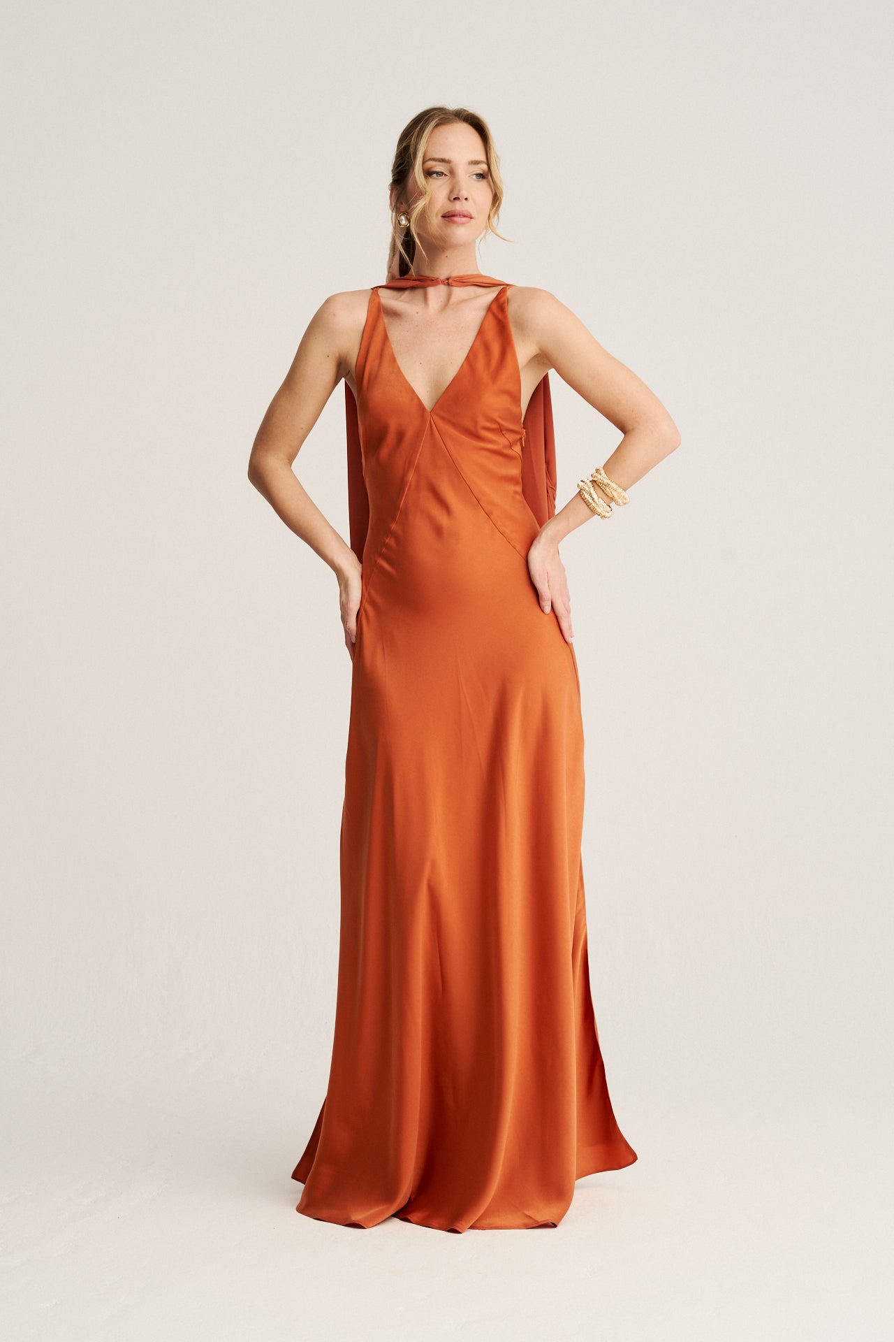 Vestido de invitada en color cobrizo sirope con silueta ajustada que realza la figura.