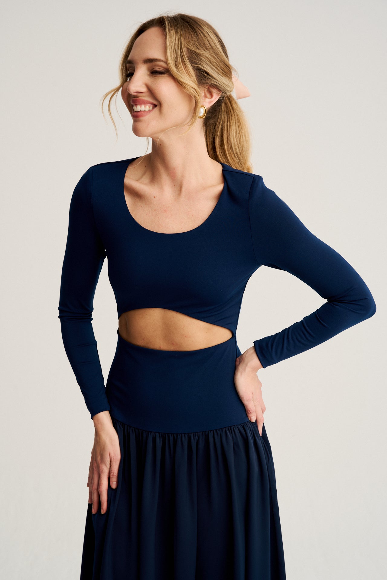 Diseño elegante con mangas largas y escote redondo, acompañado de un corte cut-out en la cintura para un toque moderno y favorecedor.