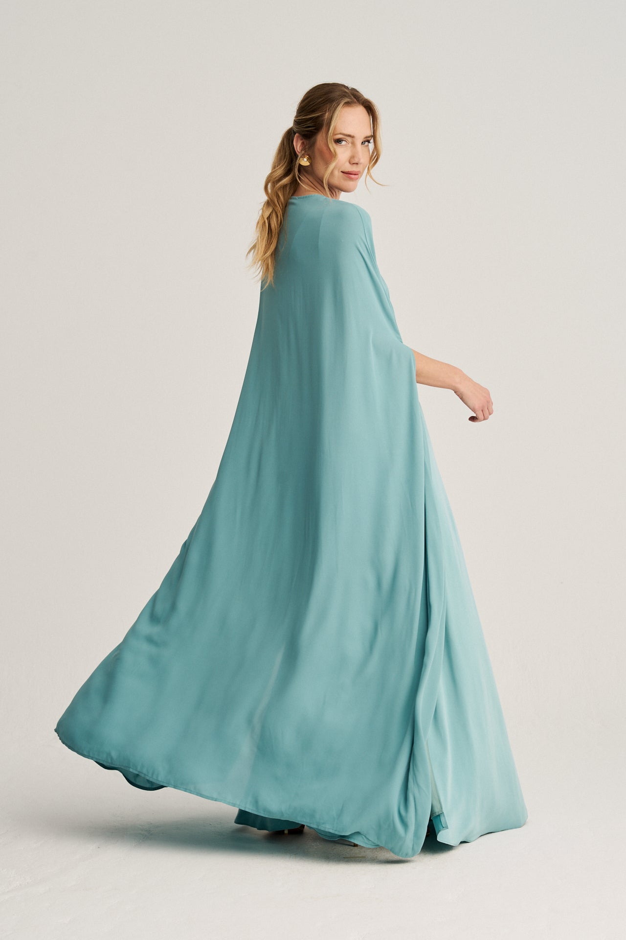 Vestido turquesa con escote en la espalda, tirantes finos y silueta estilizada para un look moderno.