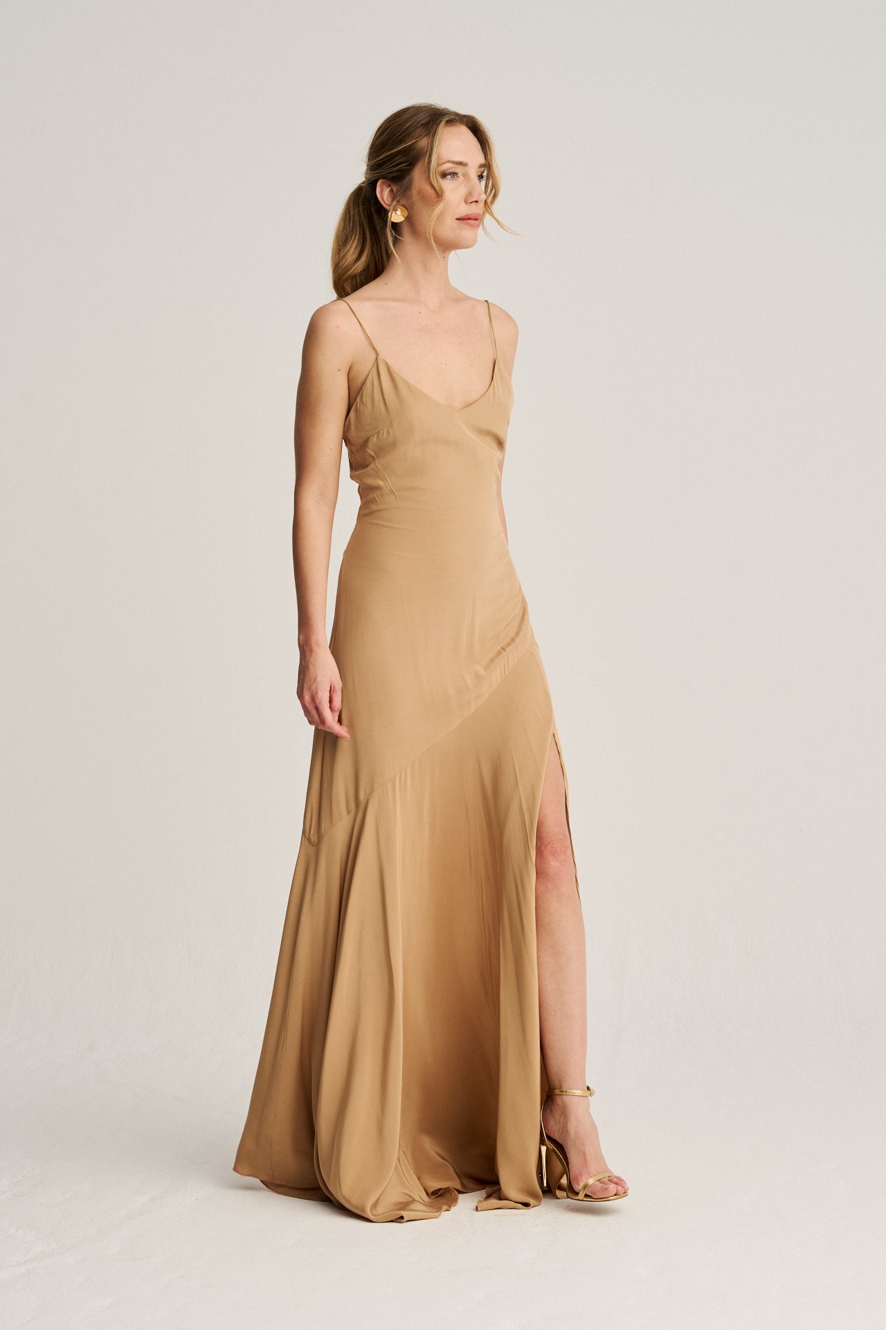 Vestido de invitada sofisticado en color toffee caramelo, con un corte asimétrico y lazadas de seda para un ajuste perfecto.