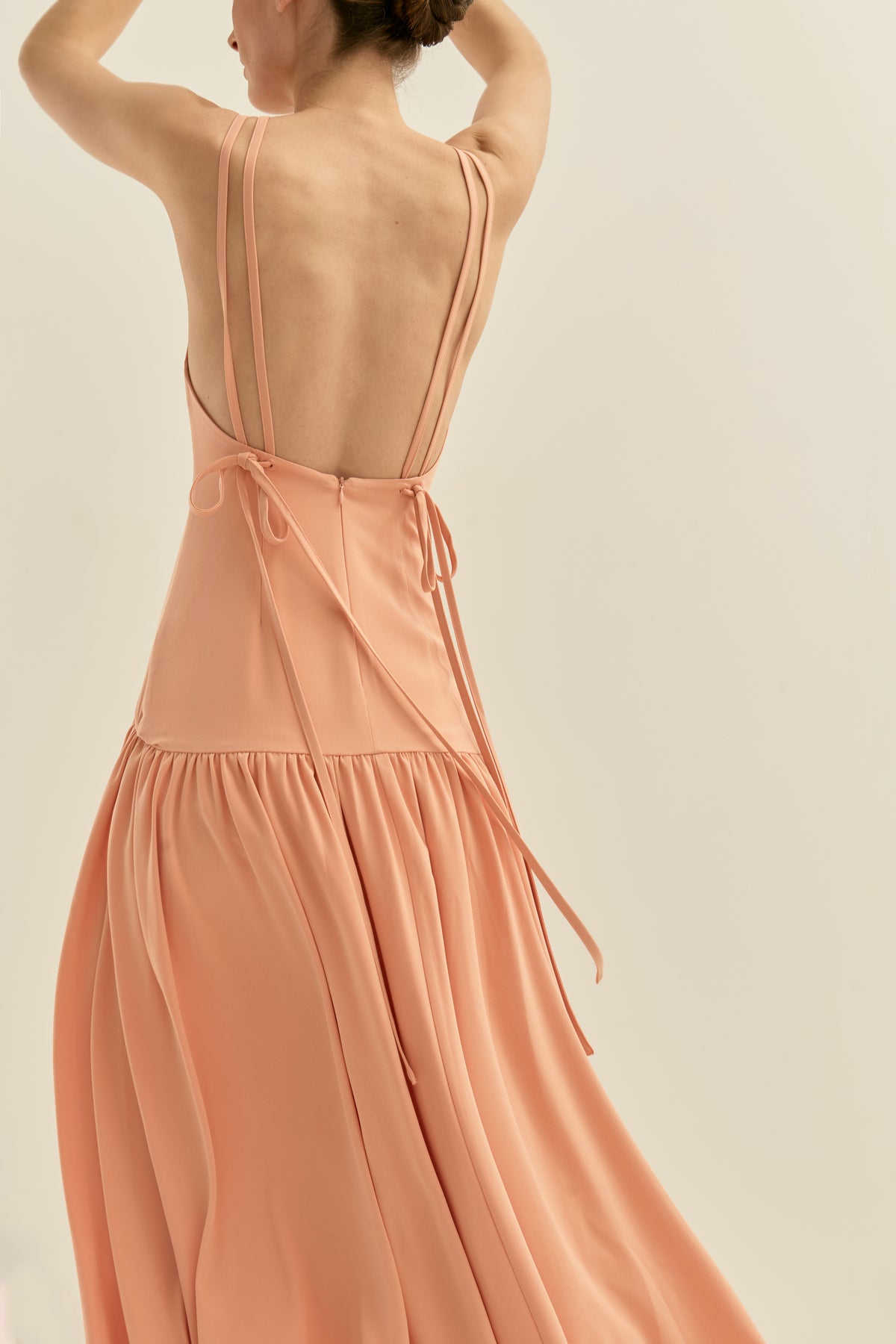 Peach-colored midi dress with an open back