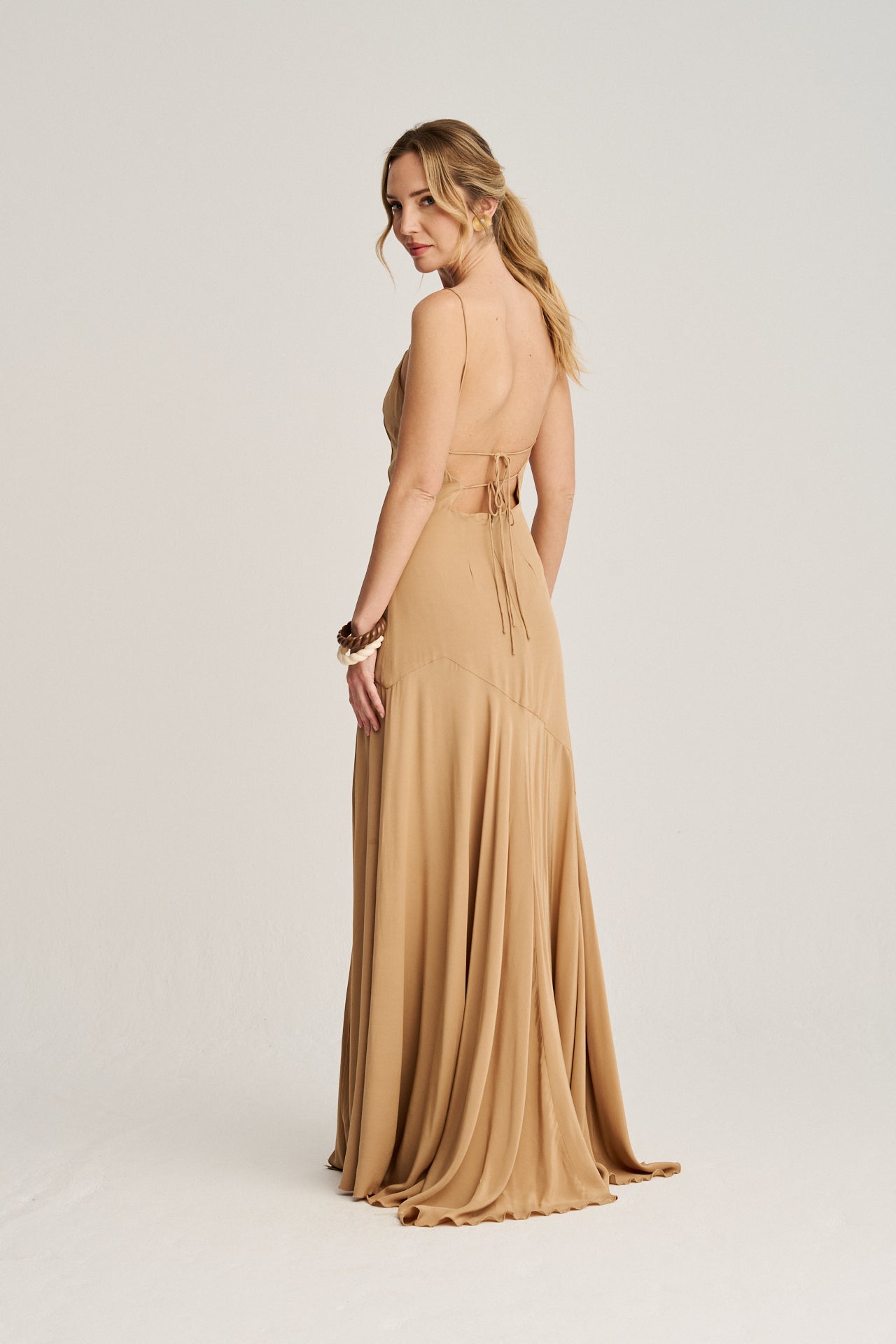 Vestido largo de invitada color toffee caramelo, con escote en la espalda y lazadas ajustables para un estilo personalizado.