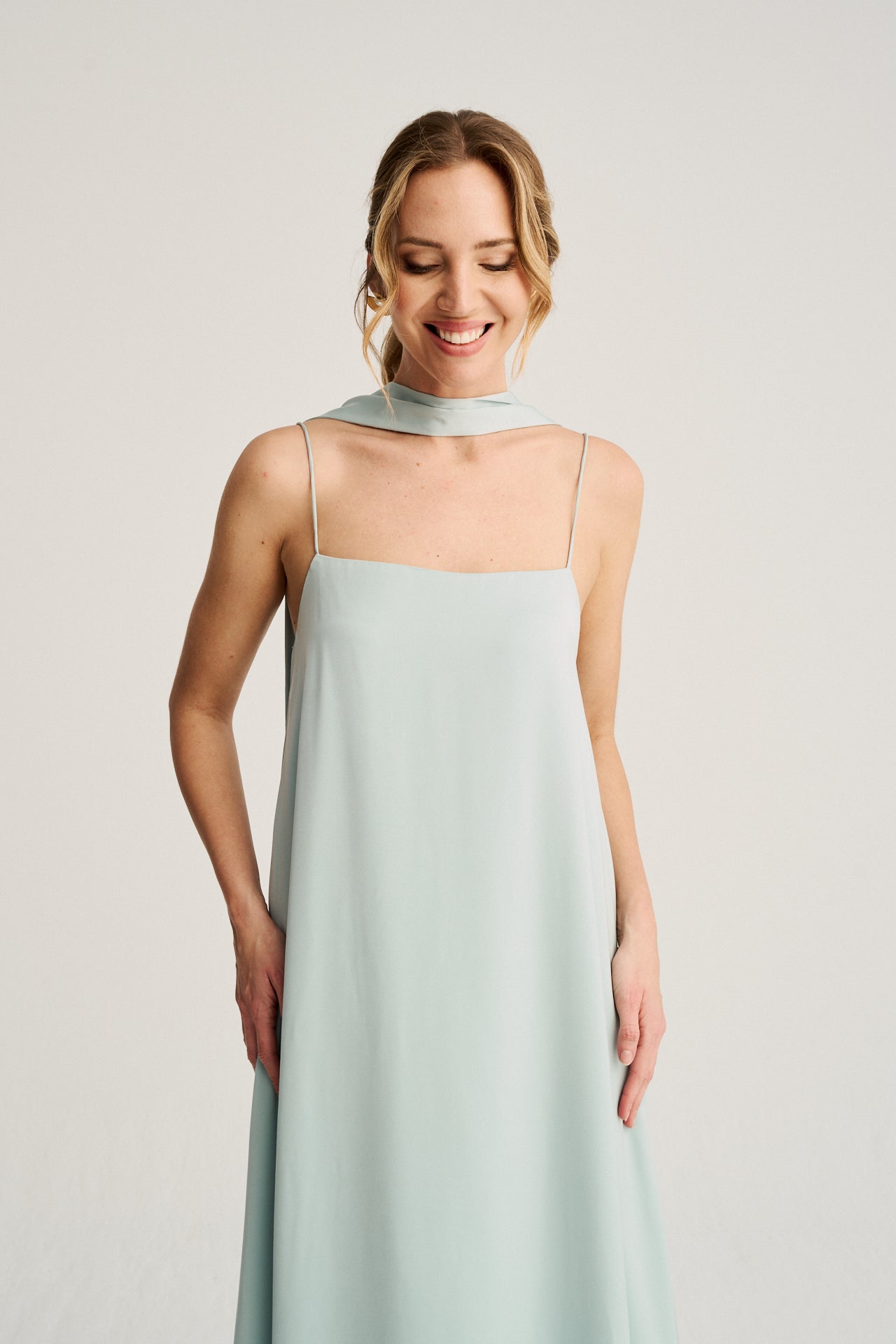 Vestido de invitada azul hielo con caída fluida, escote versátil y detalles elegantes para bodas y eventos.